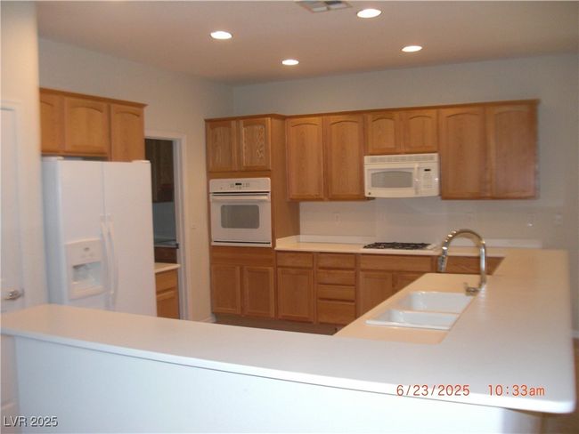 Kitchen featuring white appliances, corian counters recessed | Image 6