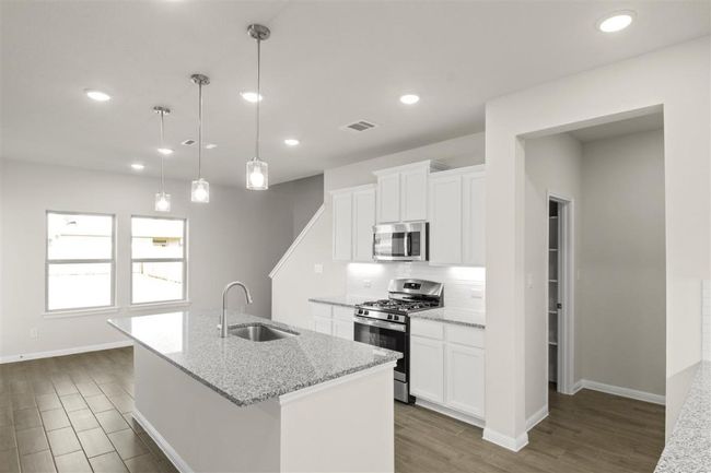 Kitchen with backsplash, a kitchen island with sink, visible vents, appliances with stainless steel finishes, and a sink | Image 14