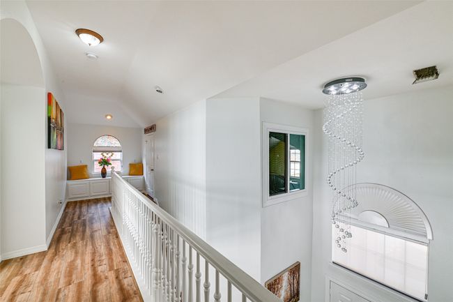 Hallway with a notable chandelier, lofted ceiling, and light hardwood / wood-style flooring | Image 21