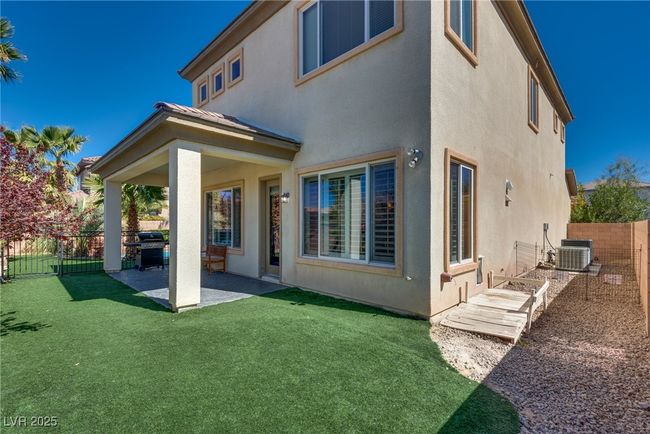 Back of property featuring a fenced backyard, stucco siding, a patio area, and a yard | Image 64