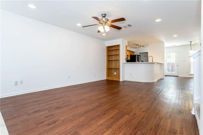 Unfurnished living room with dark wood-type flooring, a ceiling fan, and recessed lighting | Image 5