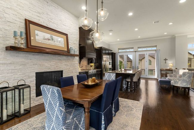 Dining area with fireplace, and dry bar. Each area has stacked stone. | Image 10