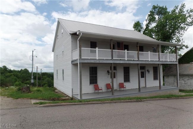 View of front of home featuring metal roof, covered porch, and a balcony | Image 6