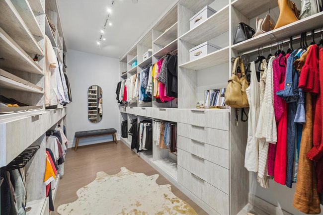 [Primary Dressing Room] Elegantly and functionally designed closet system providing ample hanging, drawer and storage space | Image 25