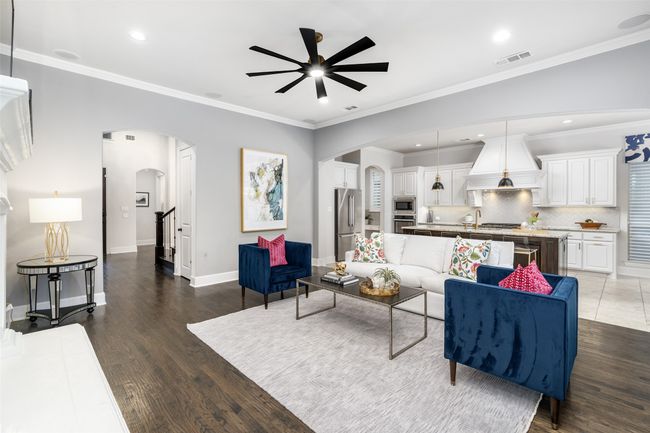 Open for entertaining, upgraded lighted fan, crown molding and the hand scraped hardwoods bring a nice feel to this living space. | Image 9