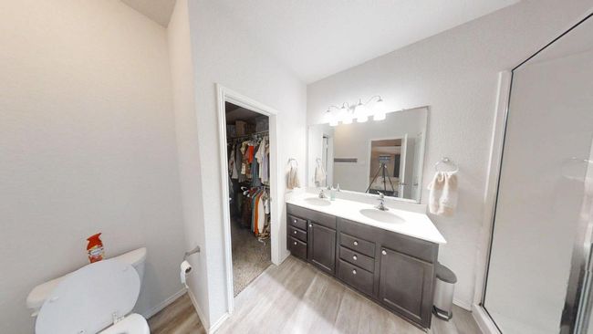 Full bath with wood finished floors, toilet, double vanity, a spacious closet, and a shower with door | Image 28