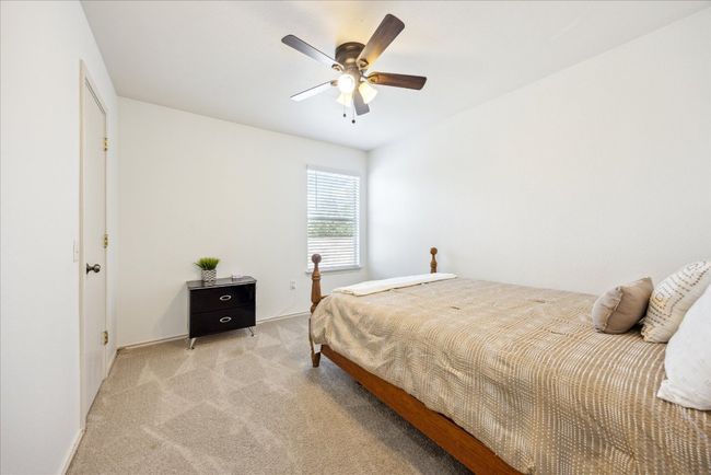 Bedroom with light carpet and a ceiling fan | Image 9