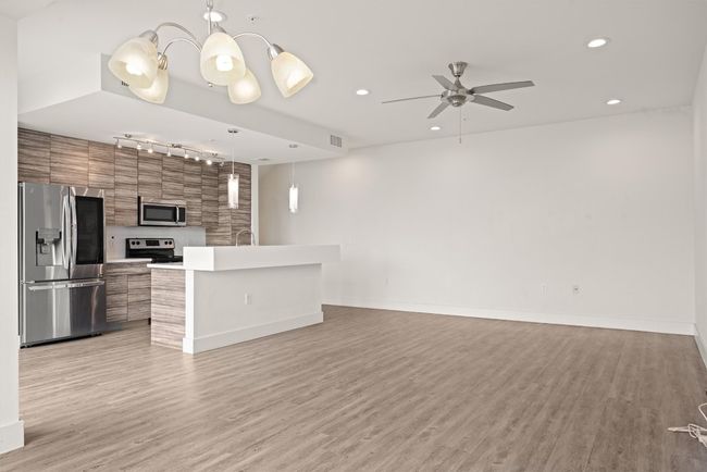 Unfurnished living room featuring track lighting, a ceiling fan, light wood-style floors, and recessed lighting | Image 7