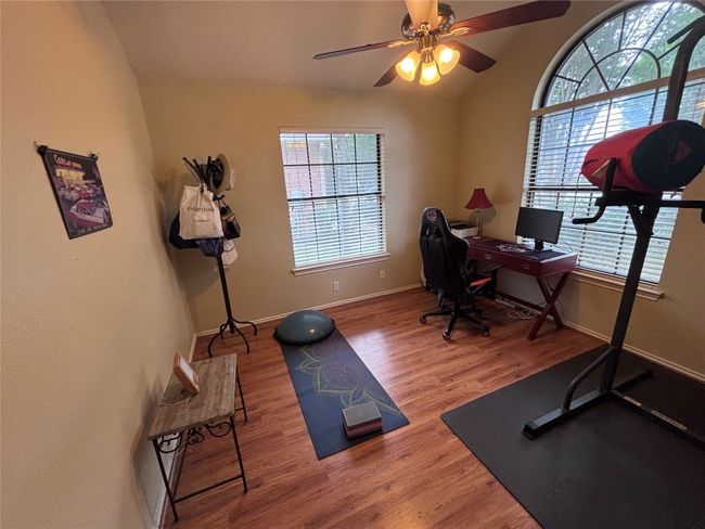 Office space featuring plenty of natural light, wood finished floors, ceiling fan, and vaulted ceiling | Image 17