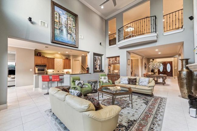 Alternate angle of the Living Area shows off the extensive openness of the home that is flooded with light from the North facing windows. Highly sought after two story Living Room offers a great view of the Gameroom that overlooks the 1st floor. Surround sound stays. | Image 8