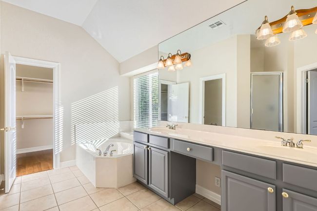 Bathroom with a shower stall, tile patterned floors, a bath, and vaulted ceiling | Image 25