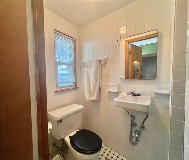 Bathroom with toilet, tile patterned floors, and tile walls | Image 20