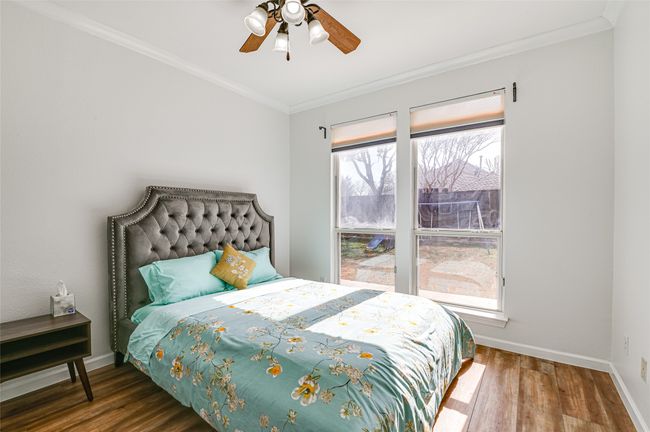 Bedroom with ornamental molding, dark wood-type flooring, and ceiling fan | Image 12