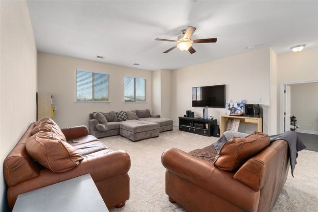Living room featuring light carpet, baseboards, visible vents, and a ceiling fan | Image 21