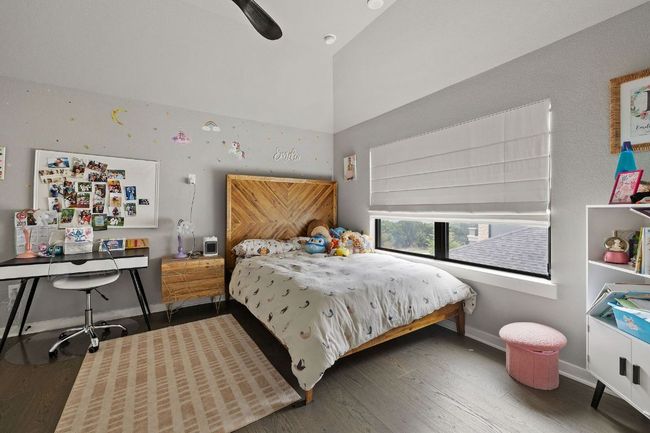 Bedroom with high vaulted ceiling, baseboards, a ceiling fan, and wood finished floors | Image 37