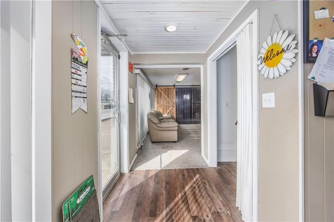 Corridor with a barn door and wood finished floors | Image 5