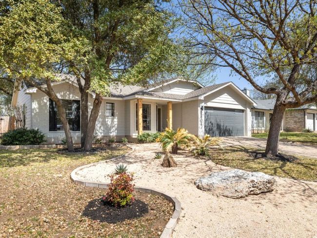 Single story home featuring brick siding, concrete driveway, and a garage | Image 8