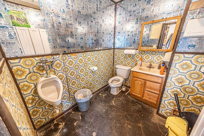 Bathroom featuring vanity, toilet, tile patterned flooring, and tile walls | Image 49