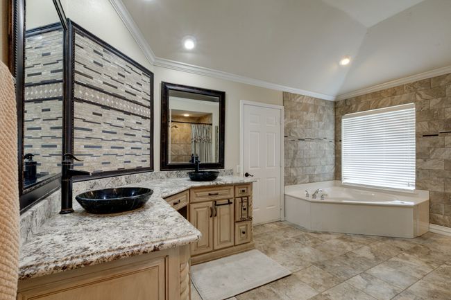 Master bathroom features crown molding, vanity, a garden tub, stand-a-lone open shower, and lofted ceiling. The door is for walkin attic access with a abundance of space. | Image 25