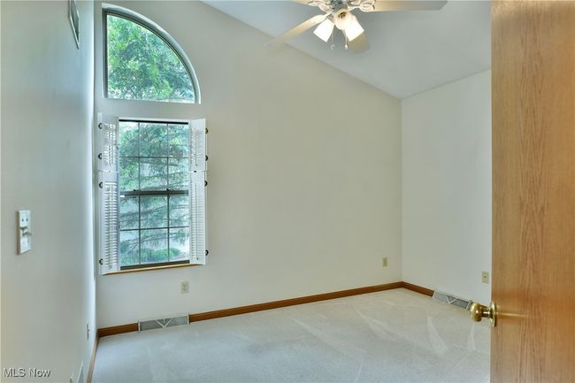 Unfurnished room featuring carpet floors, ceiling fan, and high vaulted ceiling | Image 28