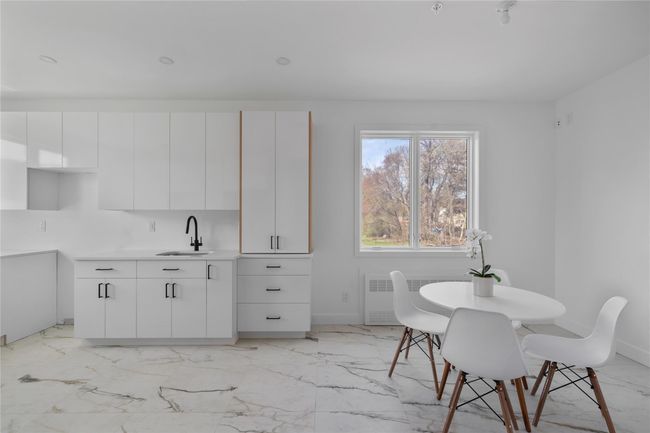 Dining room featuring radiator heating unit, marble finish floor, and baseboards | Image 12