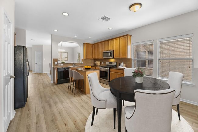 With an abundance of natural light streaming through the windows, the breakfast nook is bathed in a sunny glow, creating the perfect atmosphere to enjoy your morning coffee or a family breakfast. Virtually staged to show furniture placement. | Image 12