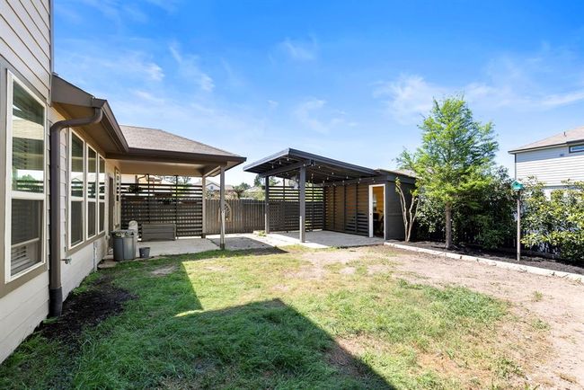 This generously sized backyard has plenty of room for activities as well as an extra covered patio & storage area. Notice all the lush landscaping throughout the backyard. | Image 39