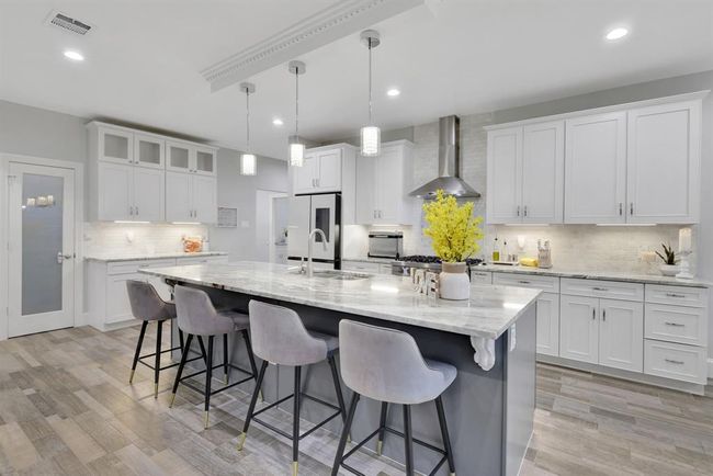 A welcoming vantage point reveals the spacious kitchen bar, comfortably seating four and creating the ideal space for casual meals, conversation, or entertaining. | Image 17