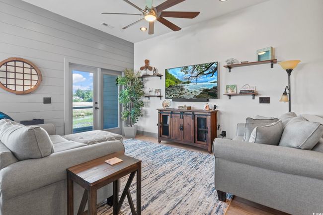 Living room with recessed lighting, wood walls, wood finished floors, visible vents, and a ceiling fan | Image 12