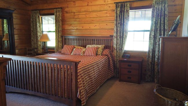 Carpeted bedroom featuring wooden walls and multiple windows | Image 15