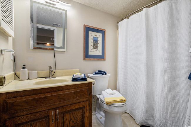 Bathroom featuring a shower with curtain, vanity, a textured ceiling, and tile patterned floors | Image 13