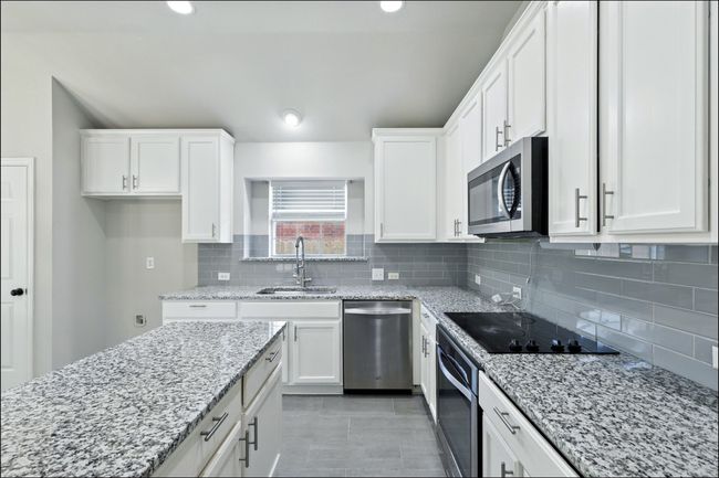 Kitchen with white cabinetry, appliances with stainless steel finishes, light stone countertops, and recessed lighting | Image 20