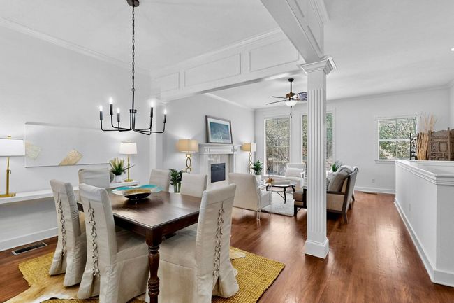 Dining space featuring ornate columns, dark wood-style flooring, ceiling fan, healthy amount of natural light, and crown molding | Image 14