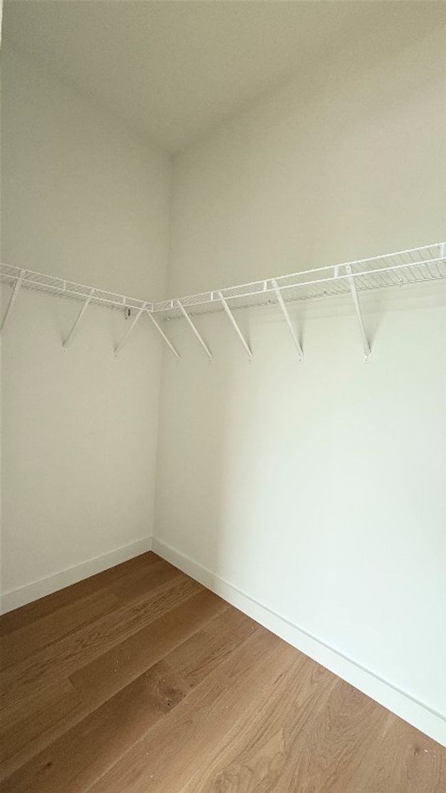 Walk in closet with wood finished floors | Image 18