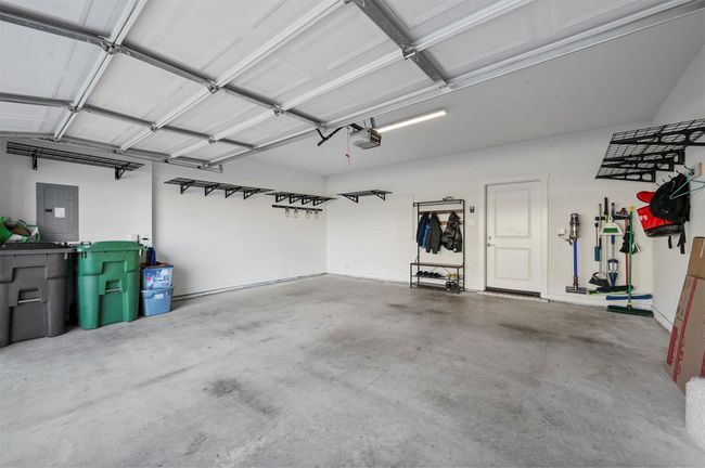 Garage featuring a garage door opener and electric panel | Image 31