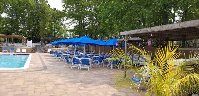 Community pool with a patio area and view of wooded area | Image 20