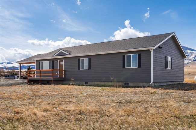 View of front of home with a wooden deck, crawl space, and roof with shingles | Image 19