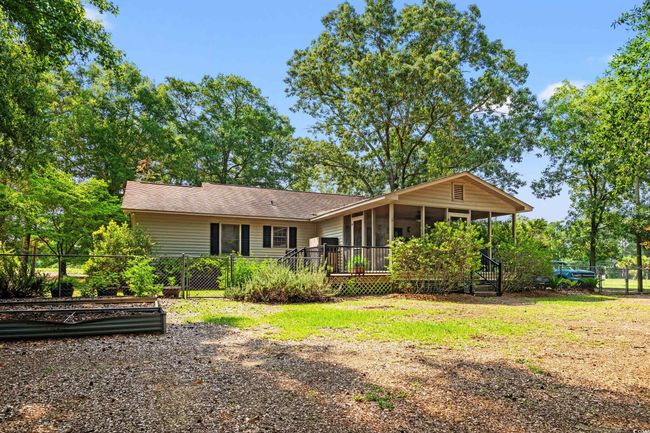 Rear view of property featuring a sunroom and a shingled roof | Image 22