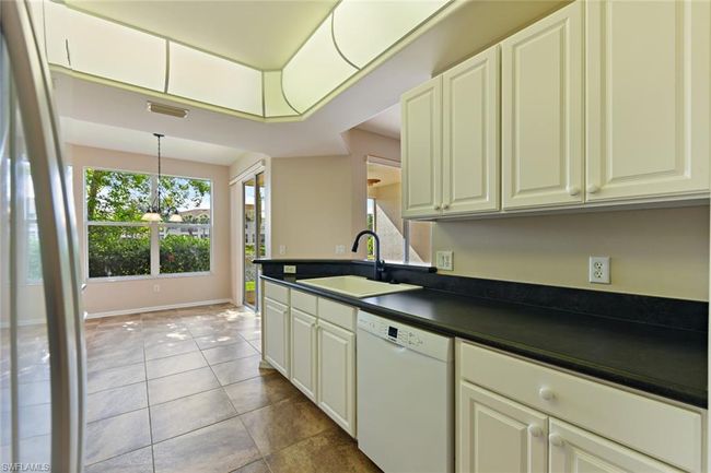 Kitchen with dark countertops, a sink, white dishwasher, and a wealth of natural light | Image 18