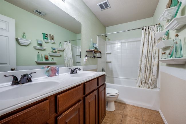 Full bathroom featuring shower / tub combo, double vanity, and tile patterned floors | Image 18