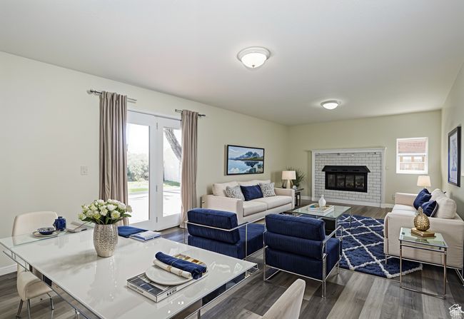 Living room featuring wood finished floors, plenty of natural light, and a brick fireplace | Image 4