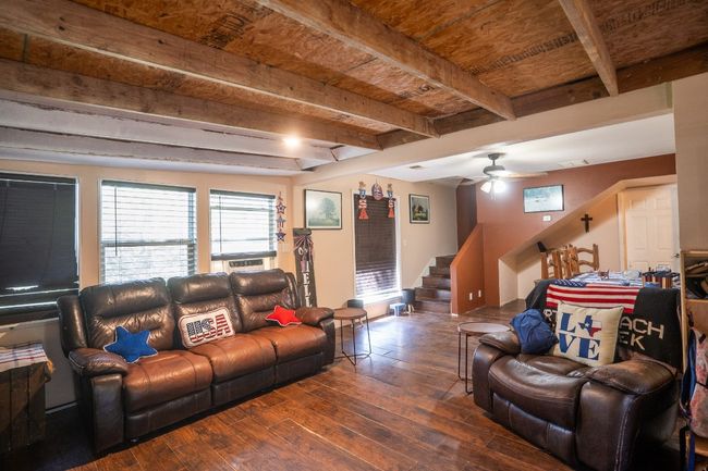 Living area with ceiling fan, stairs, beam ceiling, and hardwood / wood-style flooring | Image 15