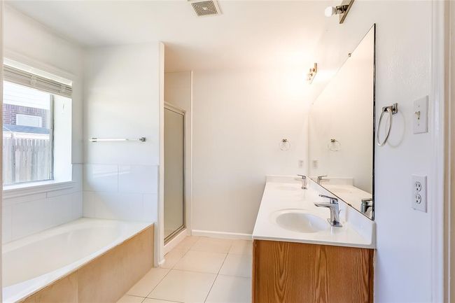 Bathroom with a garden tub, double vanity, a shower stall, and tile patterned flooring | Image 22