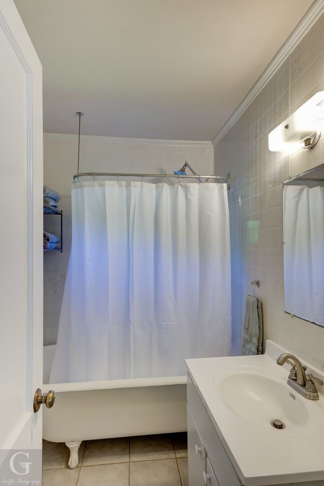 Bathroom with vanity, shower / tub combo, ornamental molding, and tile patterned floors | Image 20