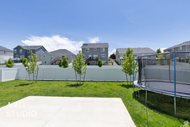 View of yard featuring a trampoline, a residential view, and a patio area | Image 27