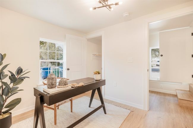 Home office featuring light wood-type flooring and a chandelier | Image 15