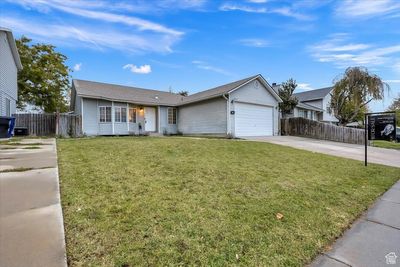 Ranch-style home with a garage and a front lawn | Image 2