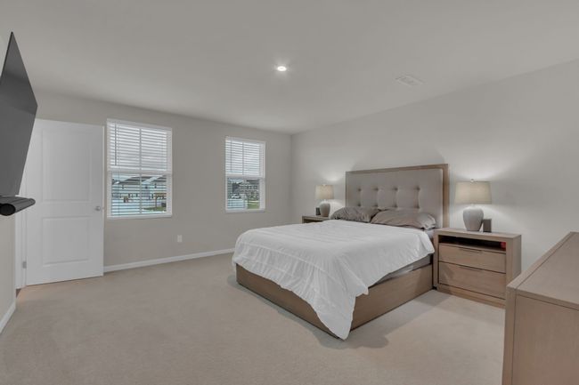 Generously sized primary bedroom on the second floor, complete with his and her closets, offering ample storage and a luxurious retreat. (*TV and wall mount bracket do not convey) | Image 29