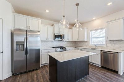 (Photo of an inventory home, actual homes finishes will vary) Welcome to the Columbus! The spacious kitchen features a large center island, quartz countertops, LVP floors, stainless appliances and more. | Image 1