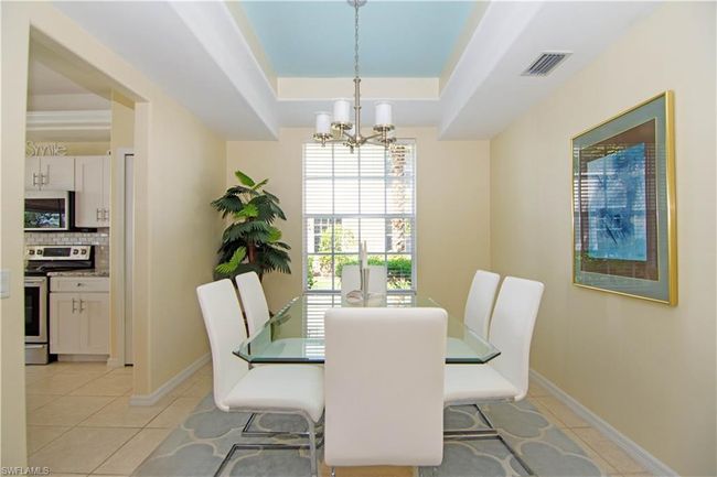 Spacious dining room with tray ceiling and chandelier accommodates 6-8 guests comfortably. | Image 8